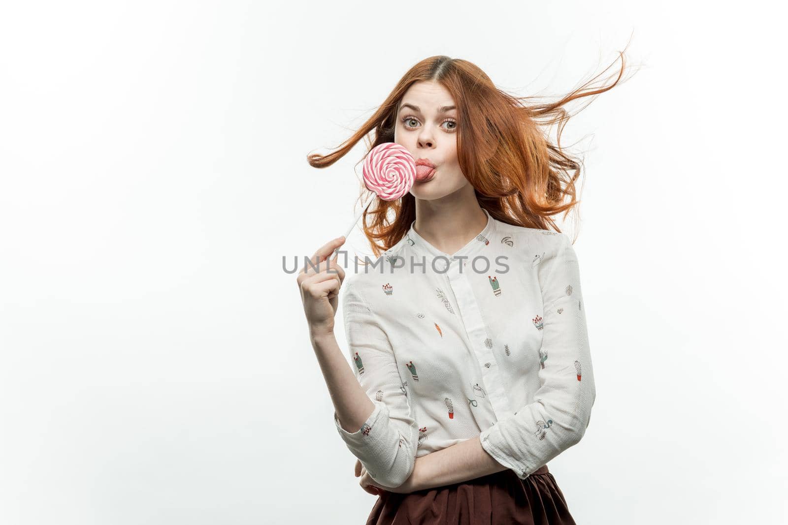 woman in white shirt with lollipop in hands charm of sweets. High quality photo