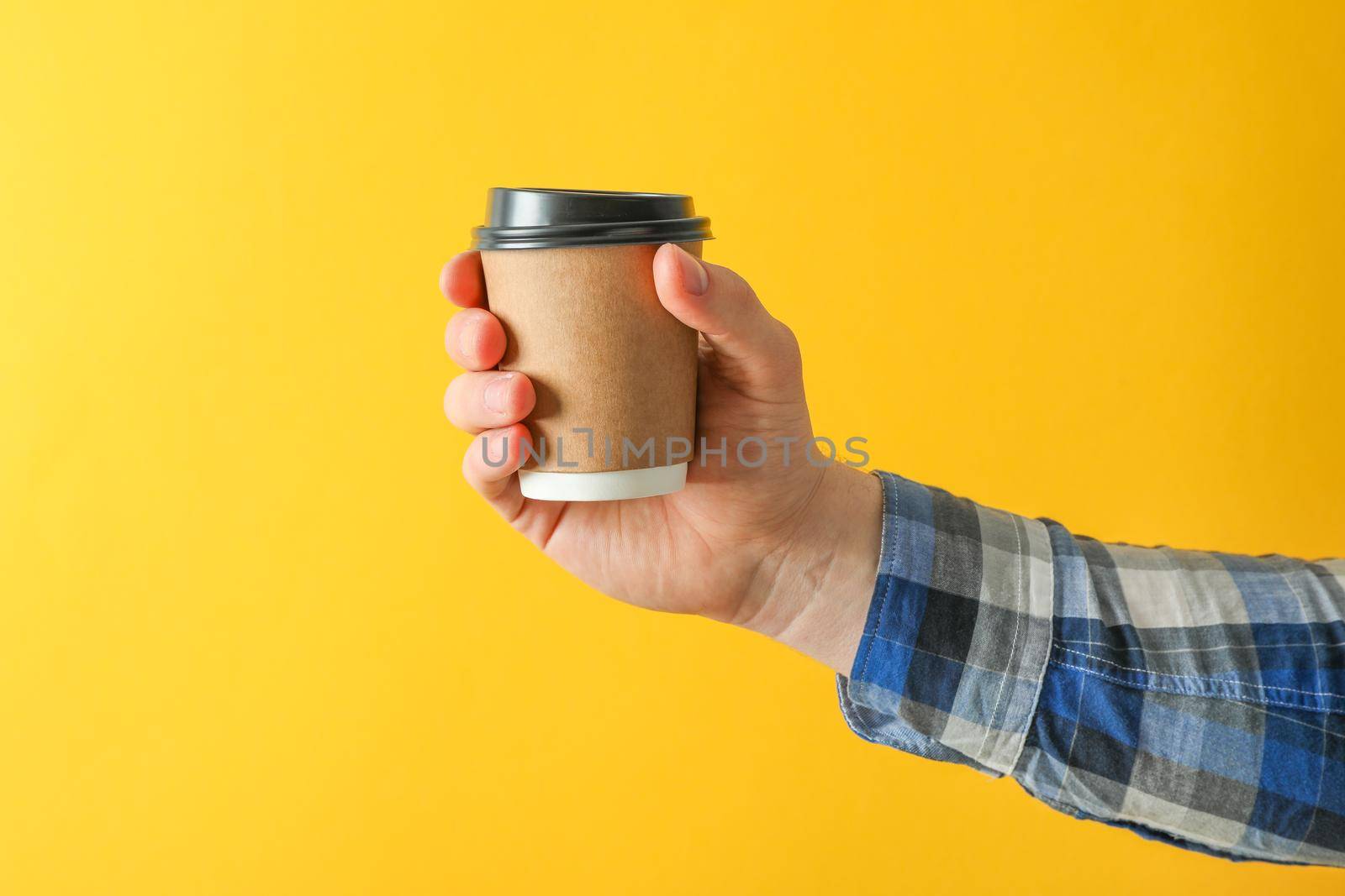 Men hand hold paper glass against color background, space for text
