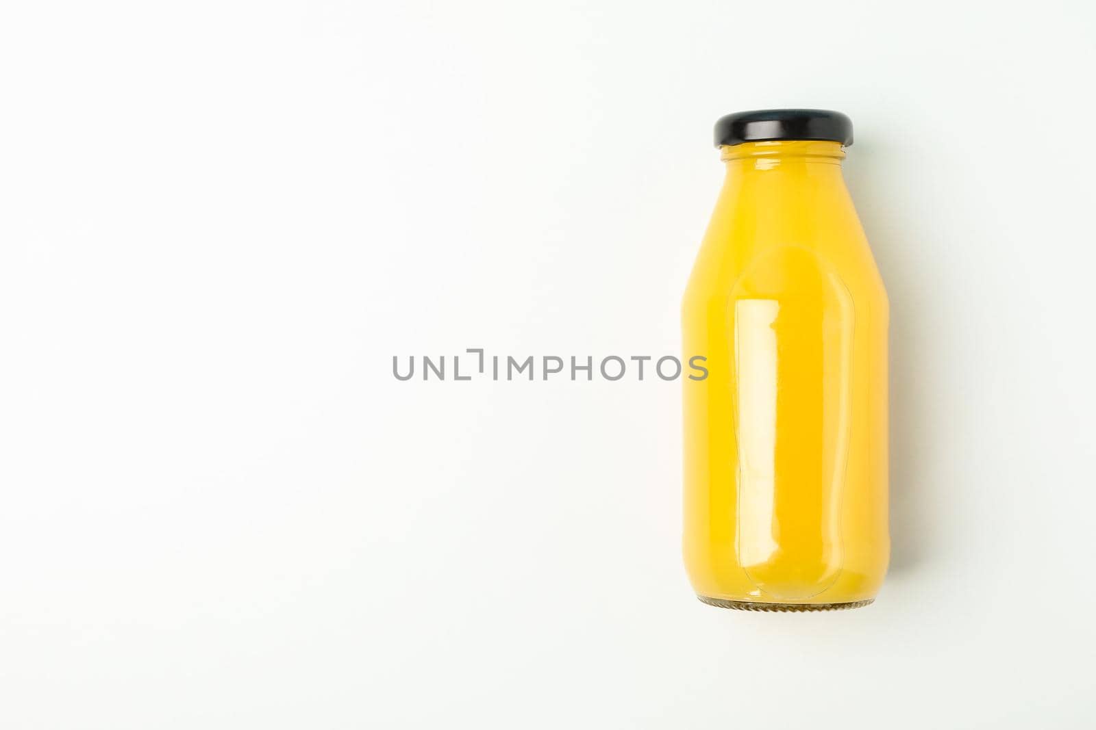 Fresh orange juice in bottle on white background, space for text. Fresh natural drink