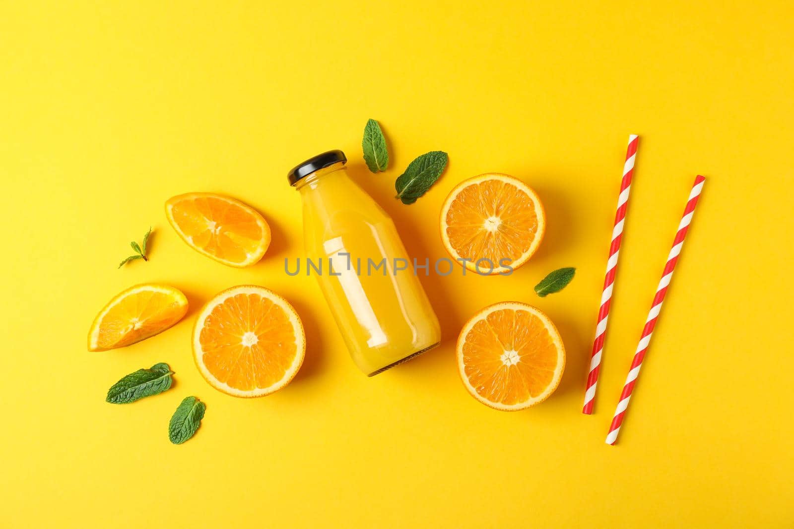 Flat lay composition with oranges, tubules and orange juice in bottle, space for text. Fresh natural drink by AtlasCompany