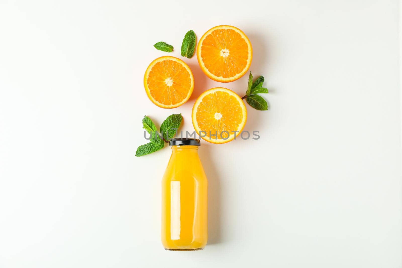 Flat lay composition with orange juice in bottle, oranges and mint on white background, space for text. Citrus drink and fruits