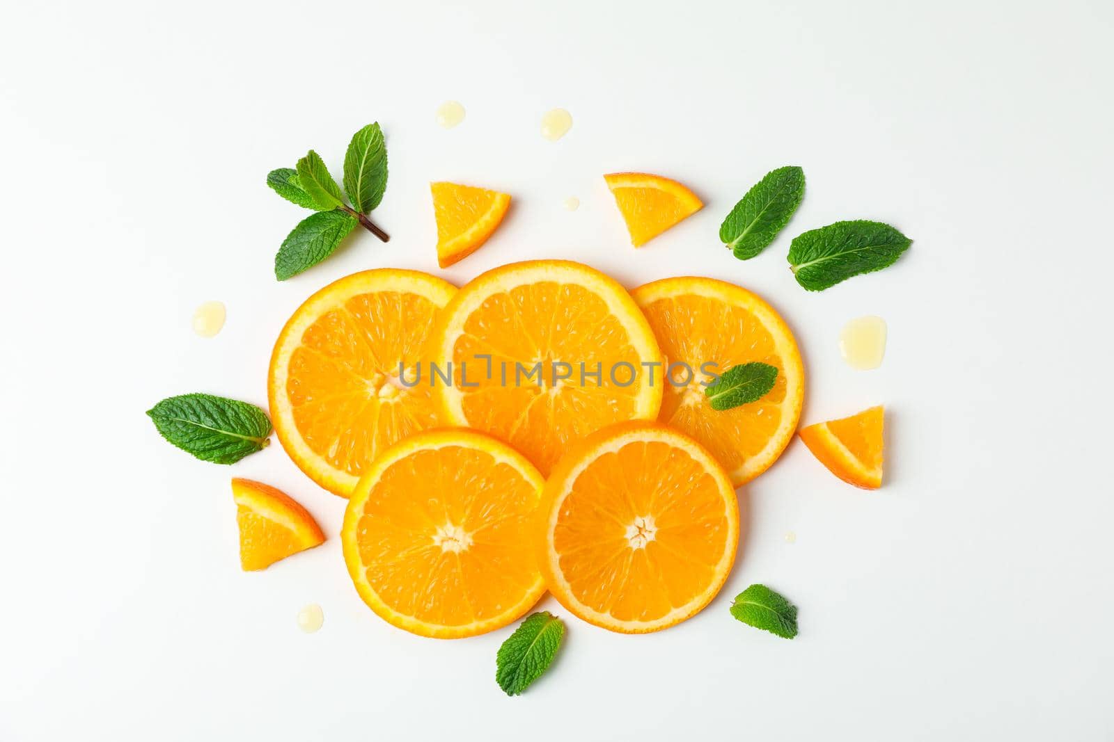 Composition with orange pieces and mint on white background, top view. Citrus fruits