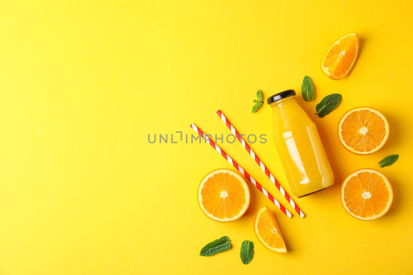 Flat lay composition with oranges, tubules and orange juice in bottle, space for text. Fresh natural drink by AtlasCompany