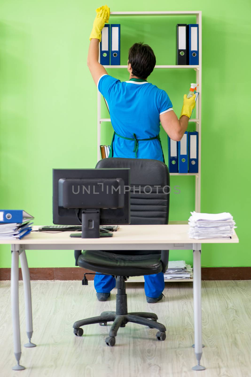 Male handsome professional cleaner working in the office