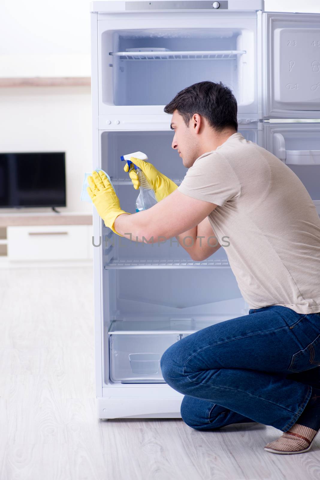 Man cleaning fridge in hygiene concept