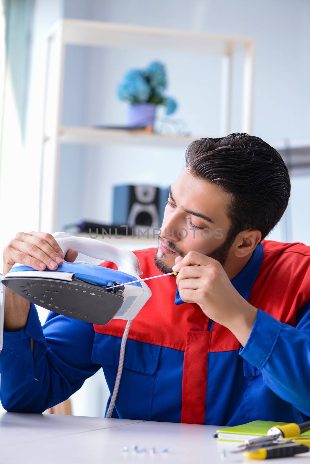 Man repairman repairing iron at service center