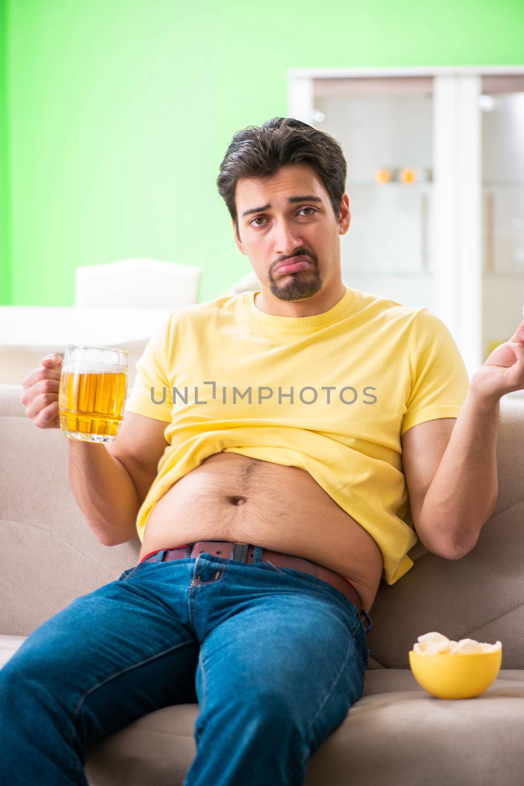 Fat obese man holding beer in dieting concept