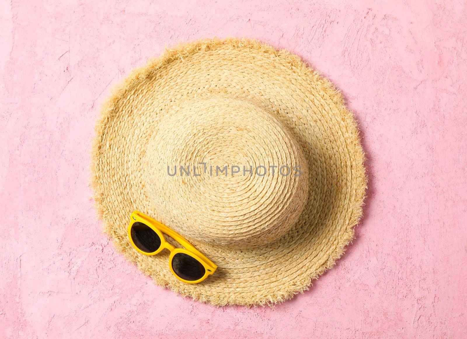 Straw hat and sunglasses on color background, space for text and top view. Summer vacation backdrop