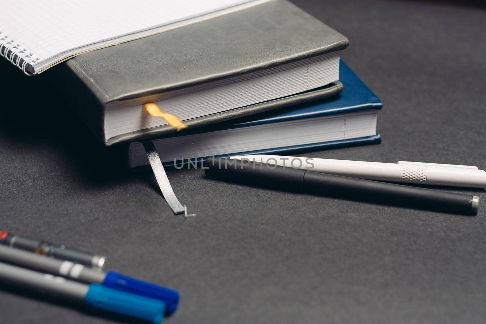 notebook books pens documents workplace office gray background. High quality photo