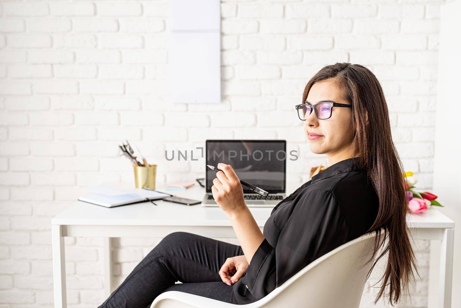 Small business concept. Portrait of young confident brunette business woman working at the office