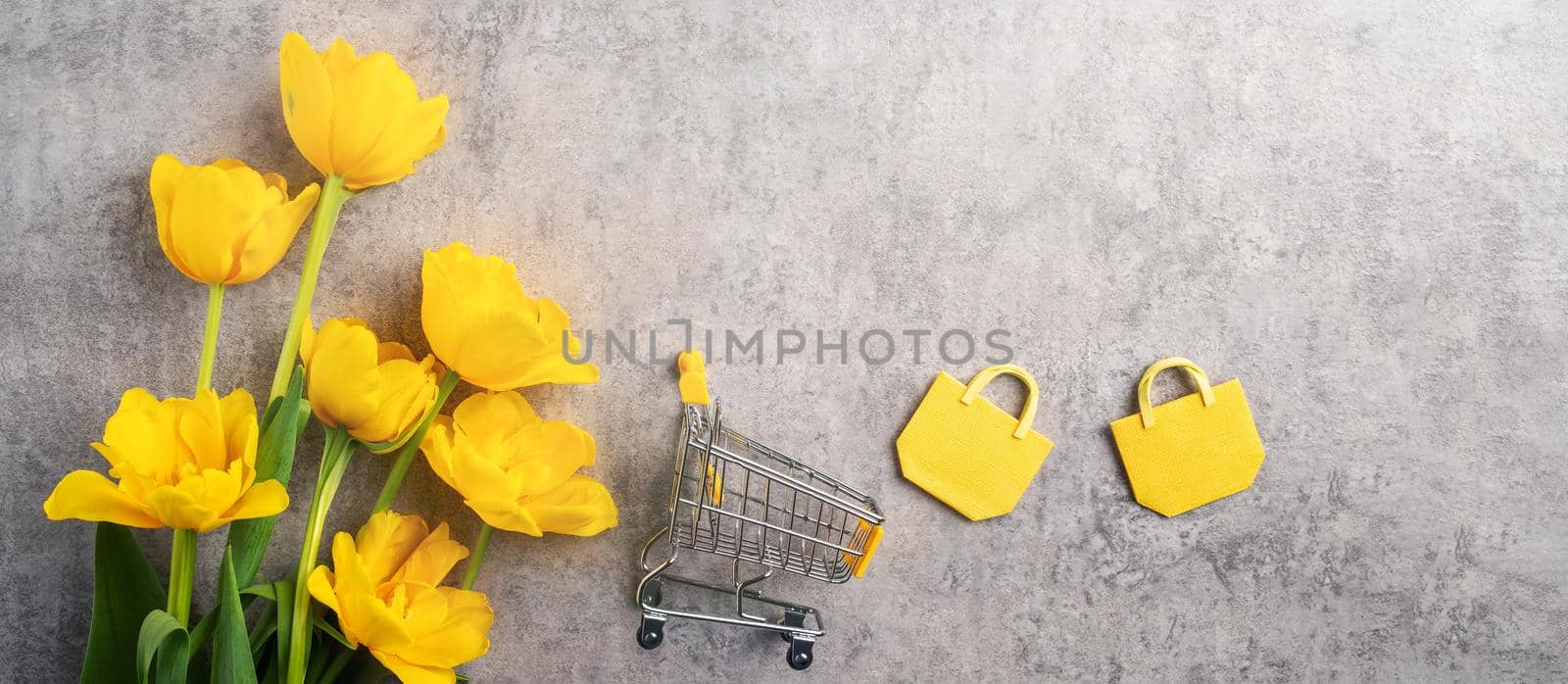 Concept of Mother's day holiday gift shopping greeting design with yellow tulip flower bouquet on gray background