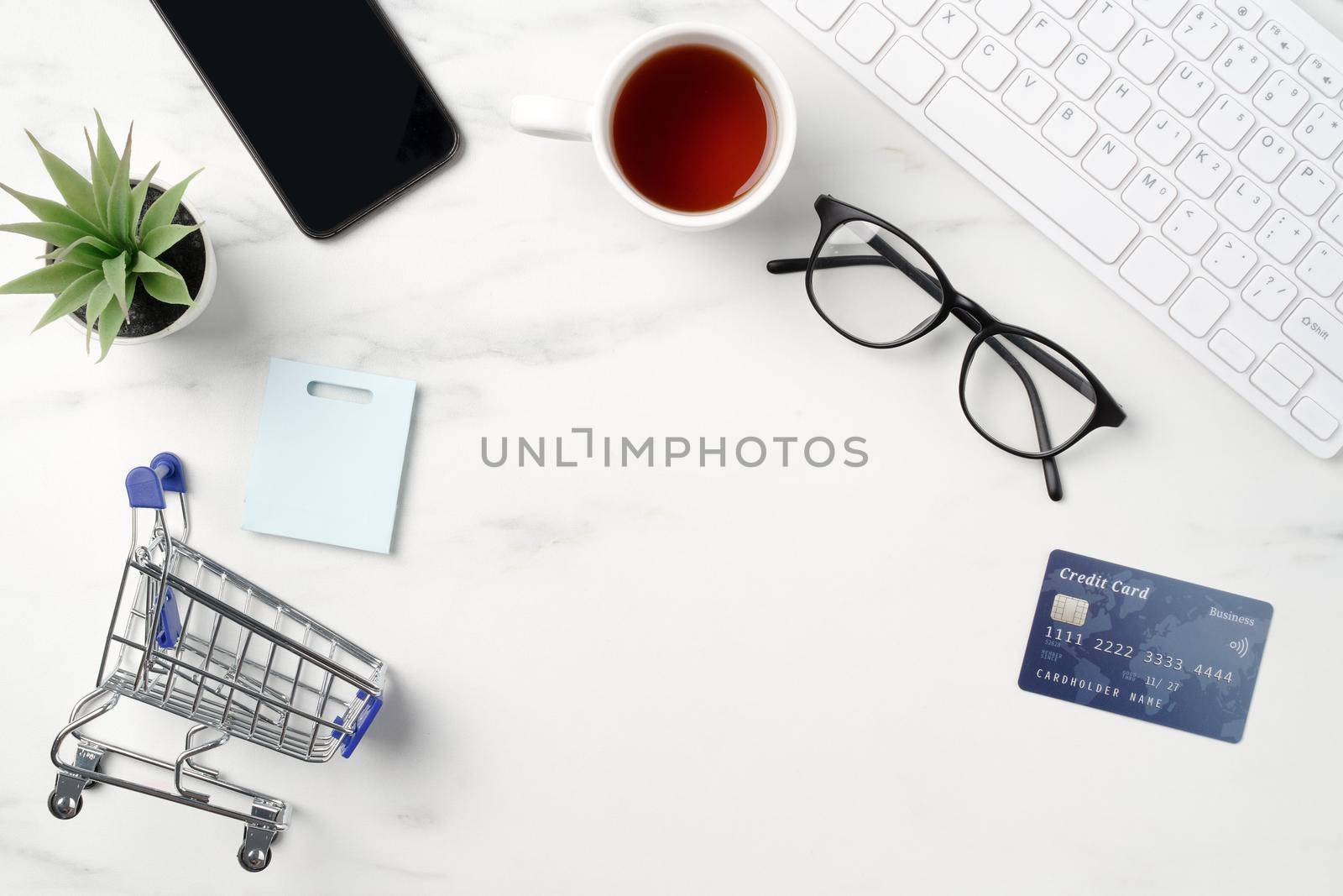 Top view of online shopping concept with credit card, smart phone and computer isolated on office marble white table background.