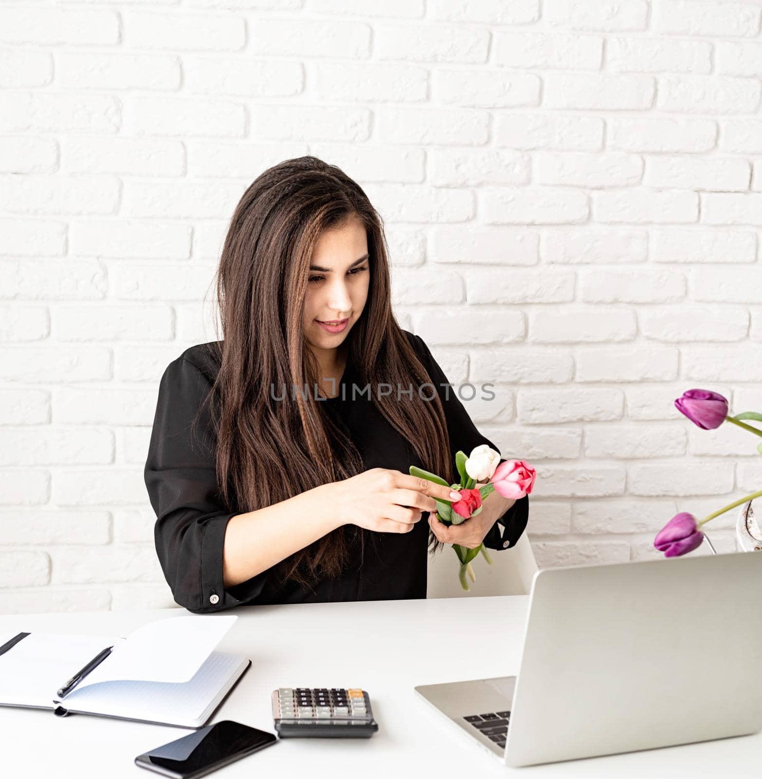 Small business concept. A young florist woman working with the client online, selecting flowers for the bouquet