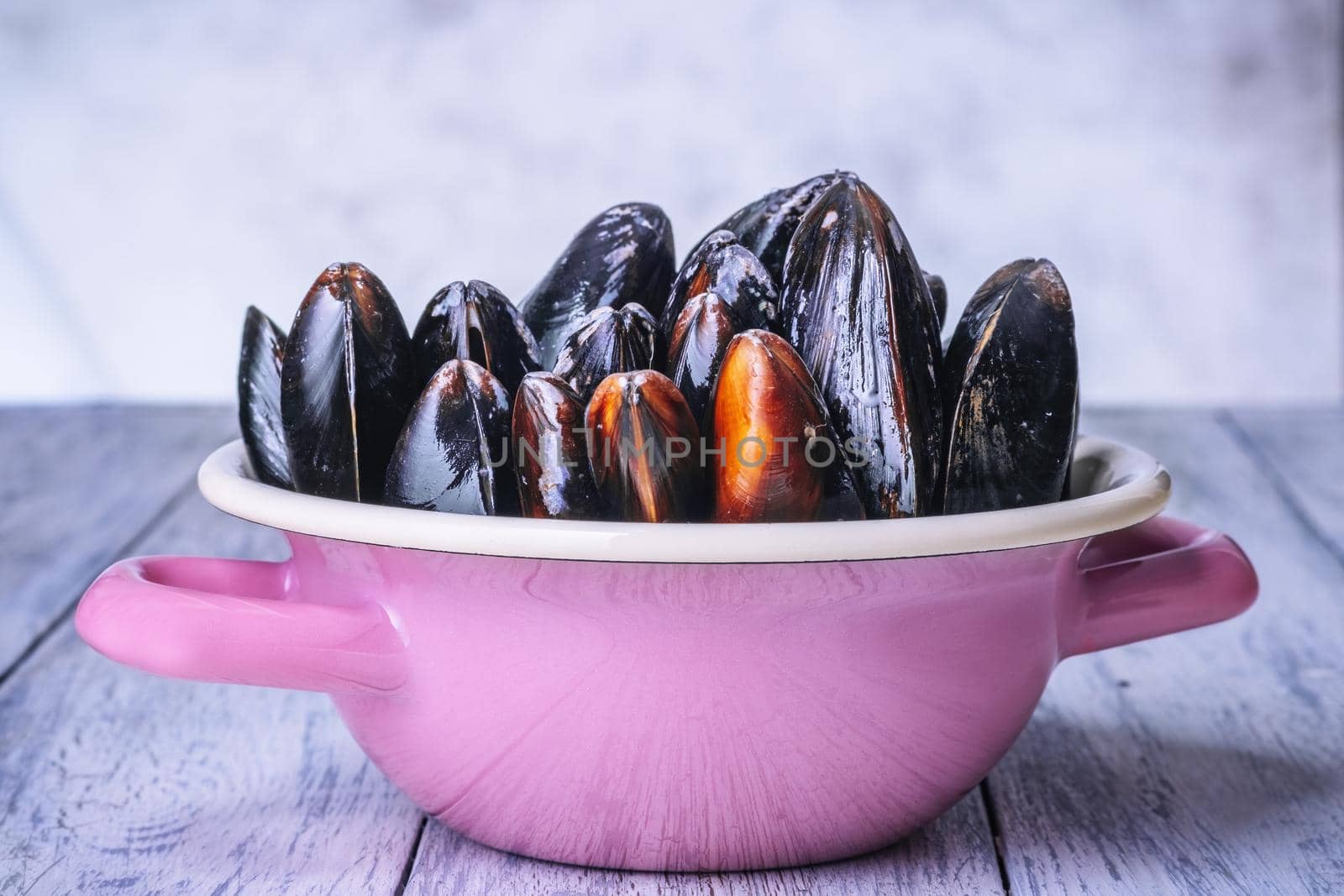 Mussels with parsley in a bowl on a wooden board. Seafood. by Fischeron