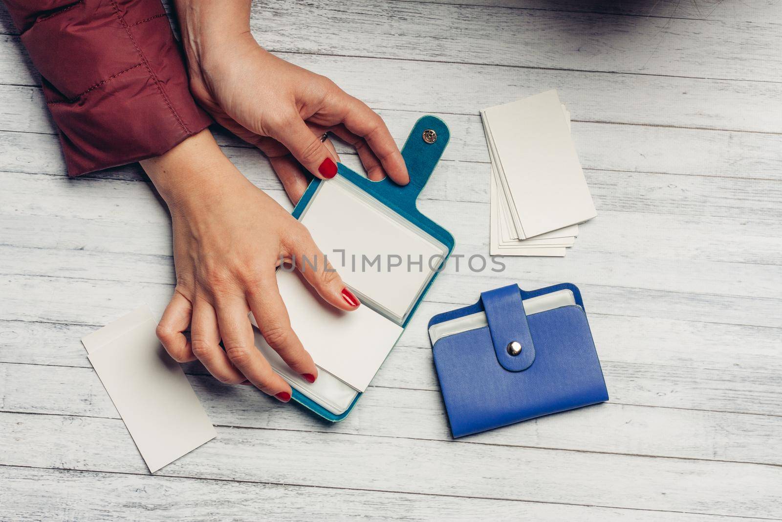 woman leafs through the sheets of business card holders on a wooden background finance sale. High quality photo