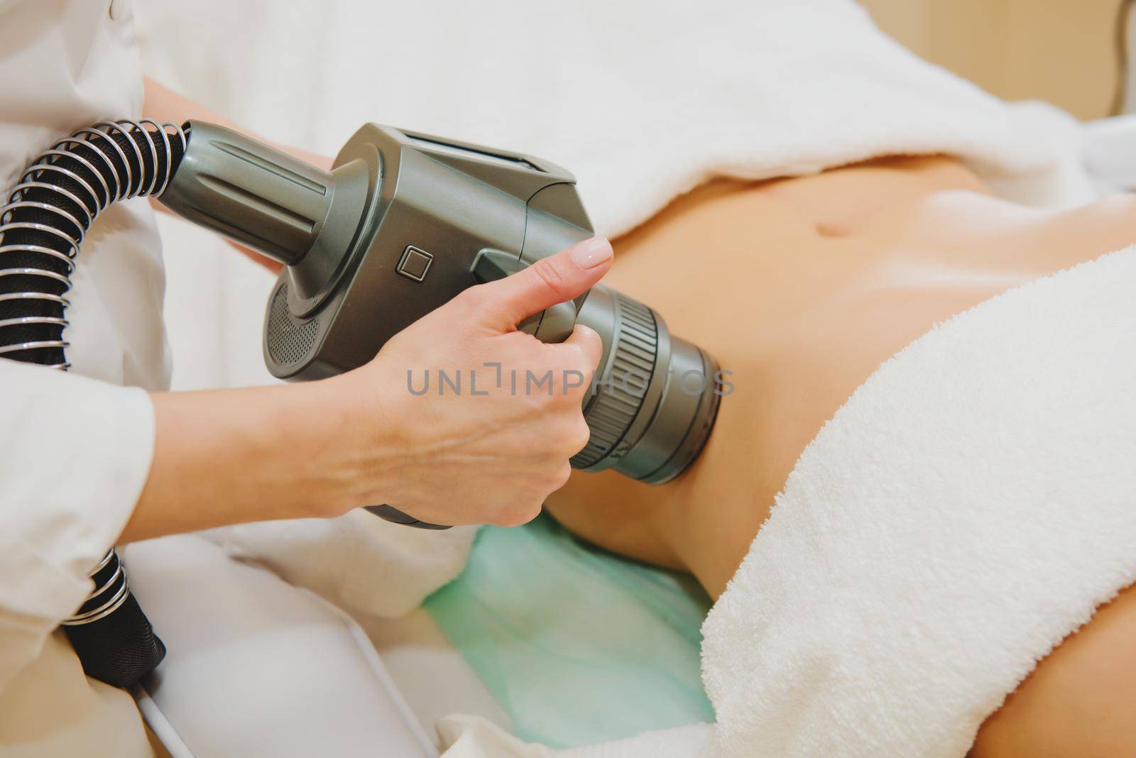 Close-up of cosmetologist doing massage with special vacuum apparatus on female belly.