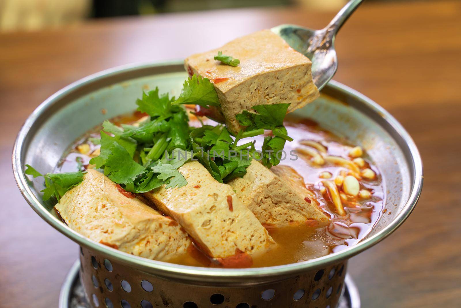 Eating stinky tofu hot pot with spicy soup using spoon, traditional street food in Taiwan.