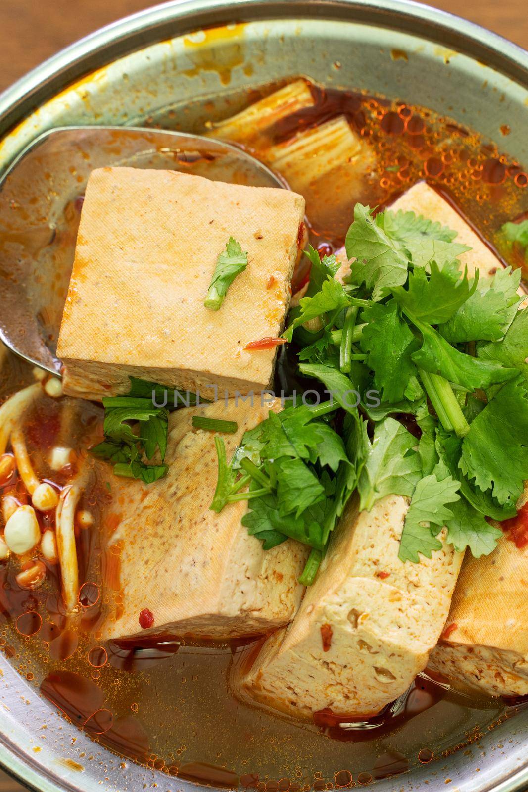 Eating stinky tofu hot pot with spicy soup using spoon, traditional street food in Taiwan.