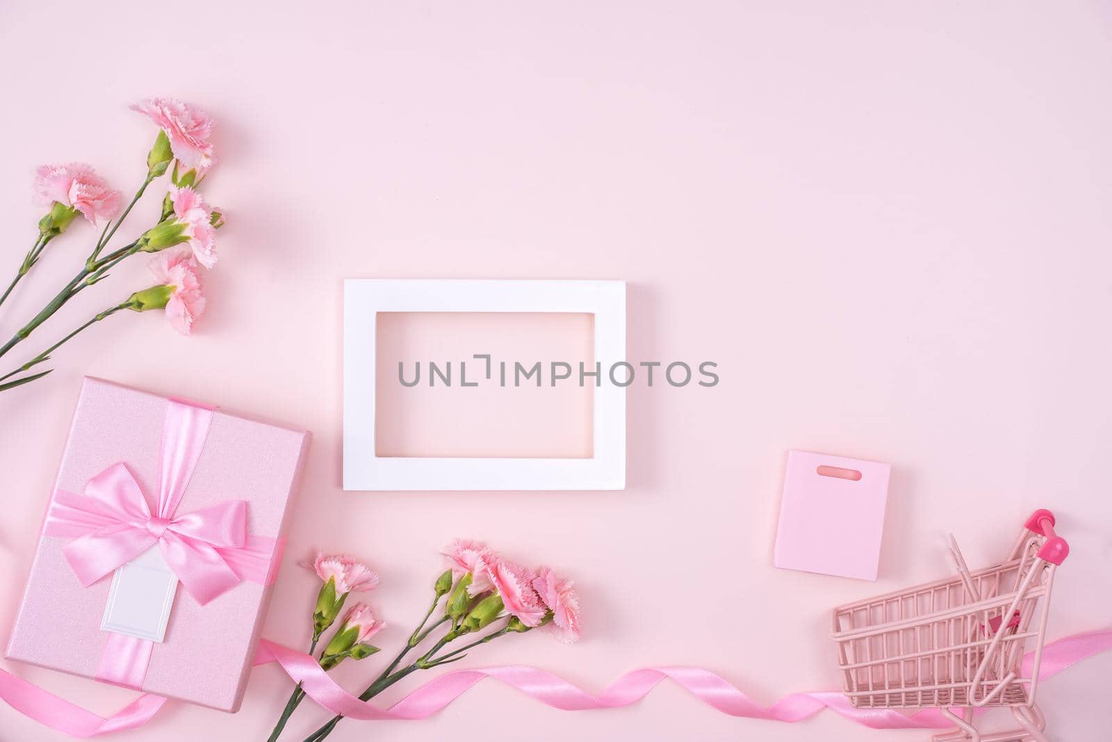 Concept of Mother's day holiday greeting design with carnation bouquet and gift on pink background