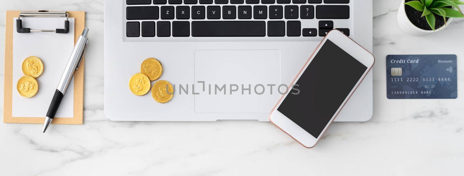 Top view of financial plan concept with credit card, laptop, note on white office table background.