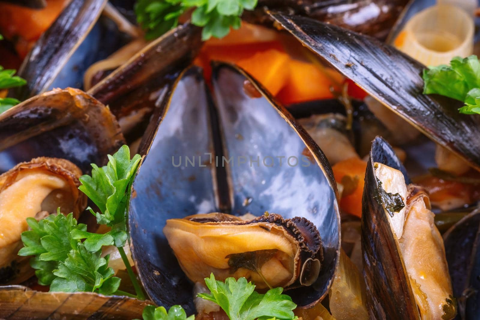 Boiled mussels in cooking dish with parsley on a wooden background by Fischeron