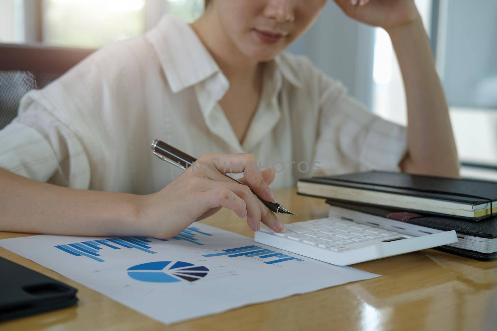 Closeup hands of businesswoman or accountant working on desk office with using a calculator to calculate the numbers, finance accounting concept.