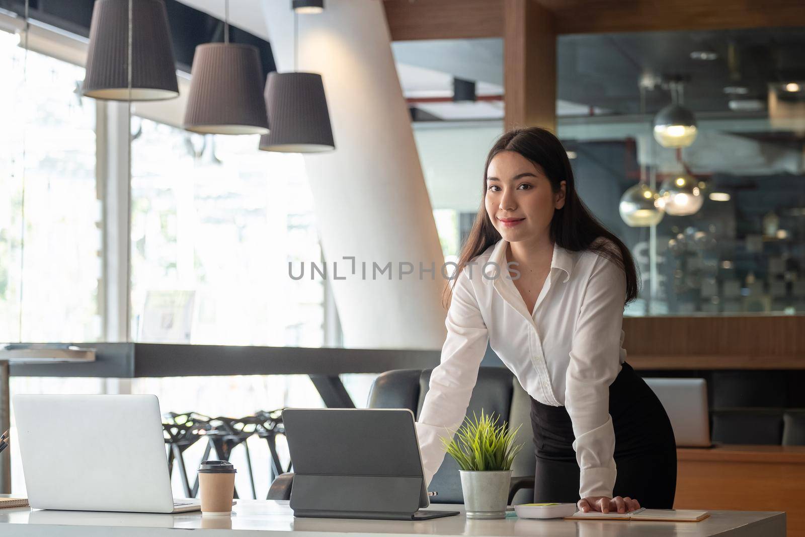 Portrait of successful teen aged businesswoman standing at her office - Business Concept.