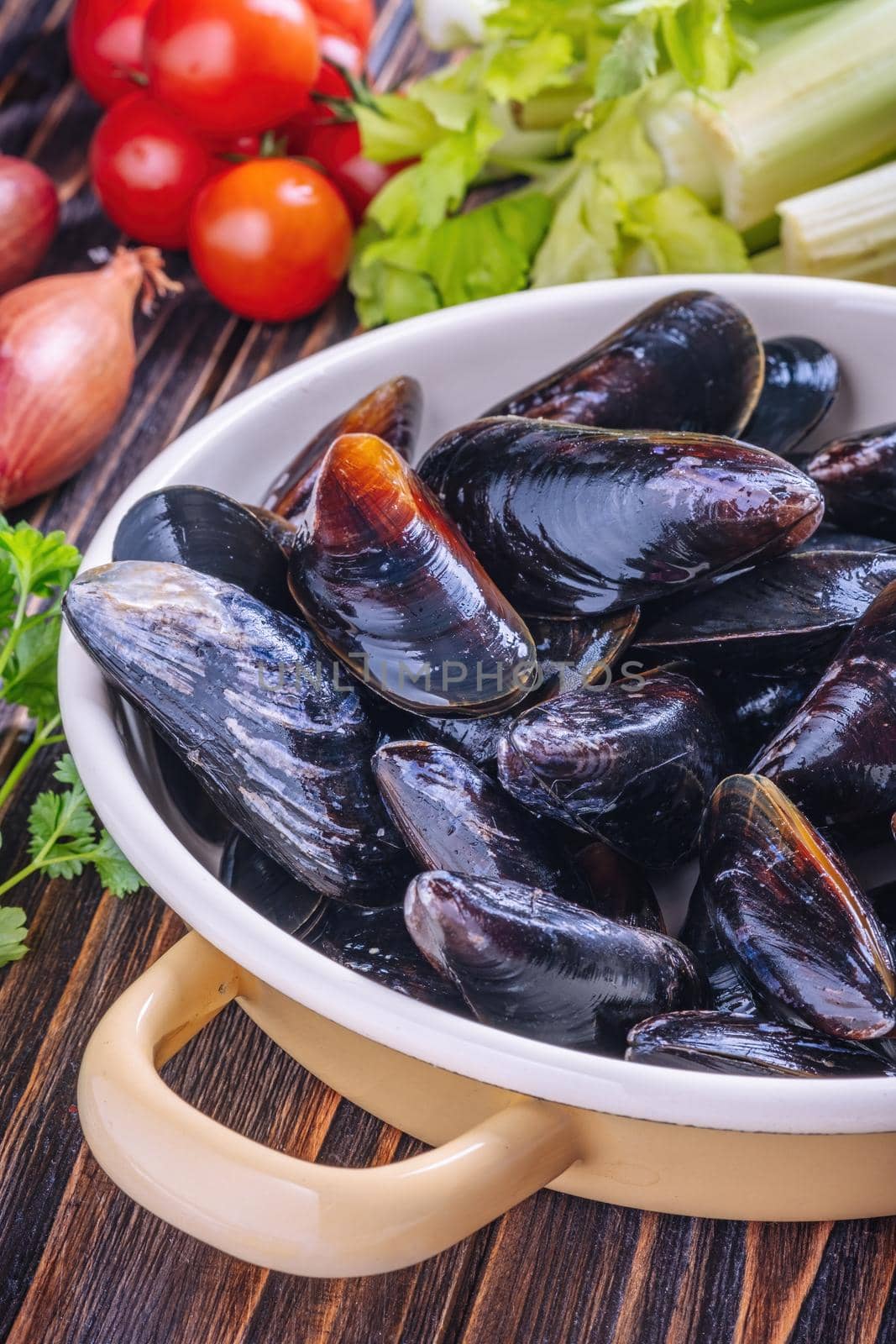 Mussels with parsley in a bowl on a wooden board. Seafood. by Fischeron