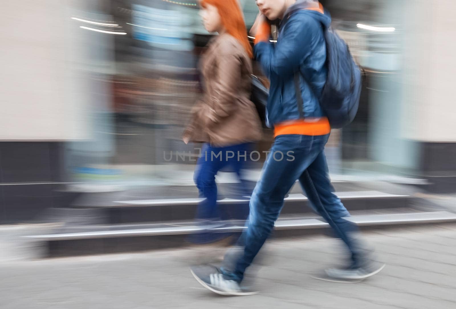 A group of young people going along the street. Intentional motion blur