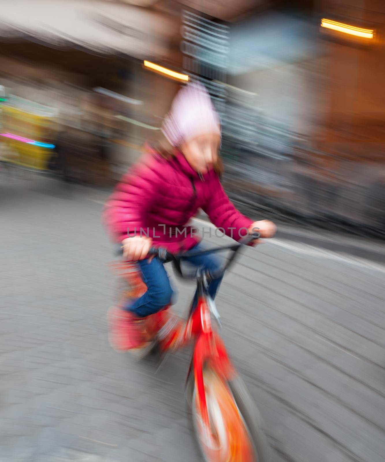 Abstract image of little girl riding a bike on the city streets