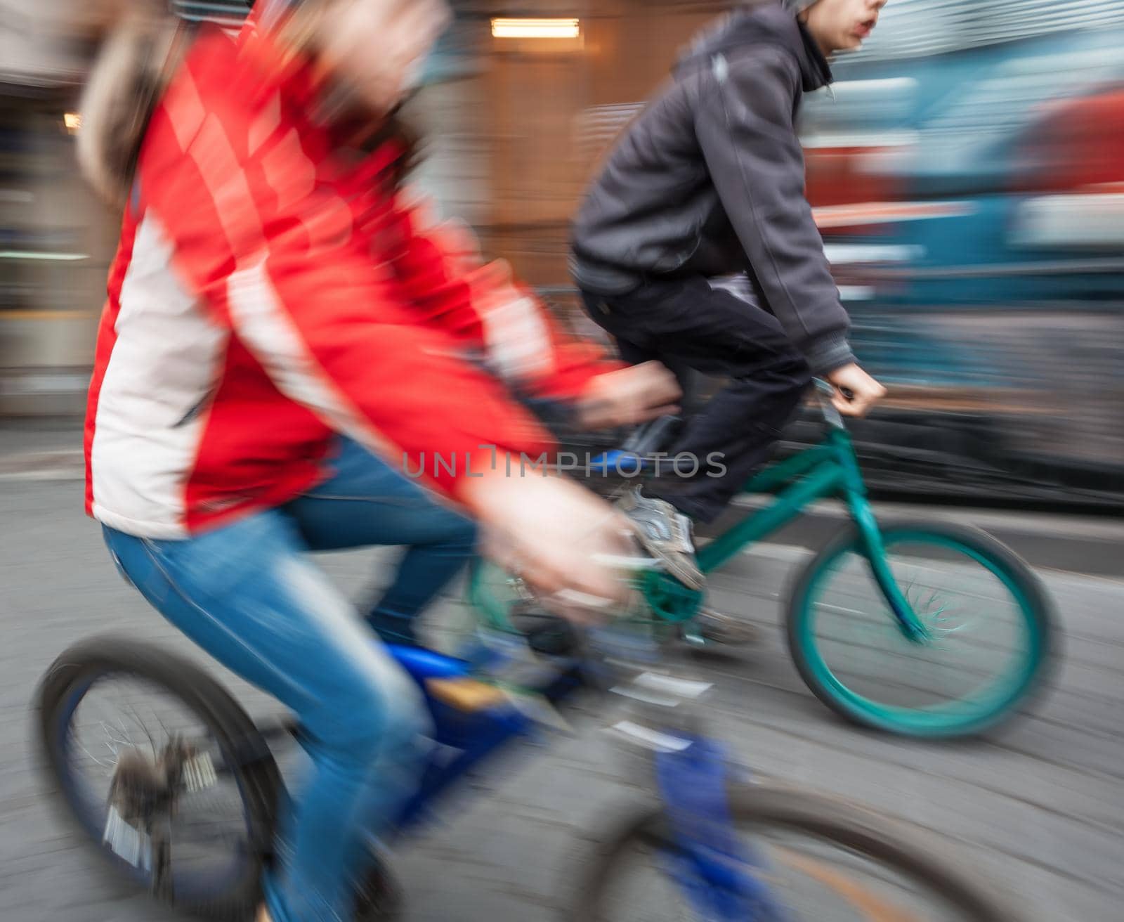 Two young boys on bicycles in the city. Intentional motion blur