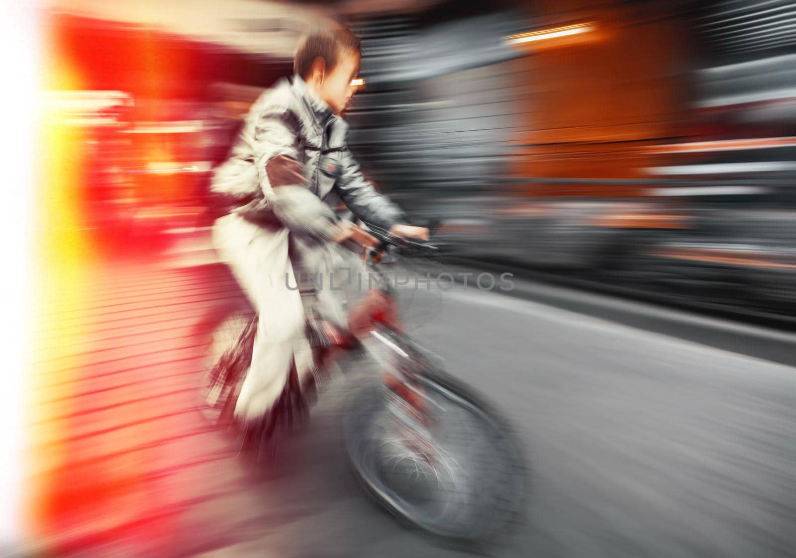 Cyclist boy on the city roadway. Intentional motion blur