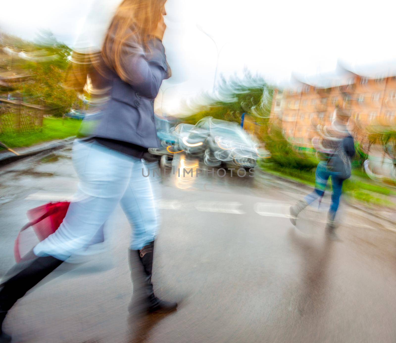 Man crossing the street at a crosswalk. Intentional motion blur