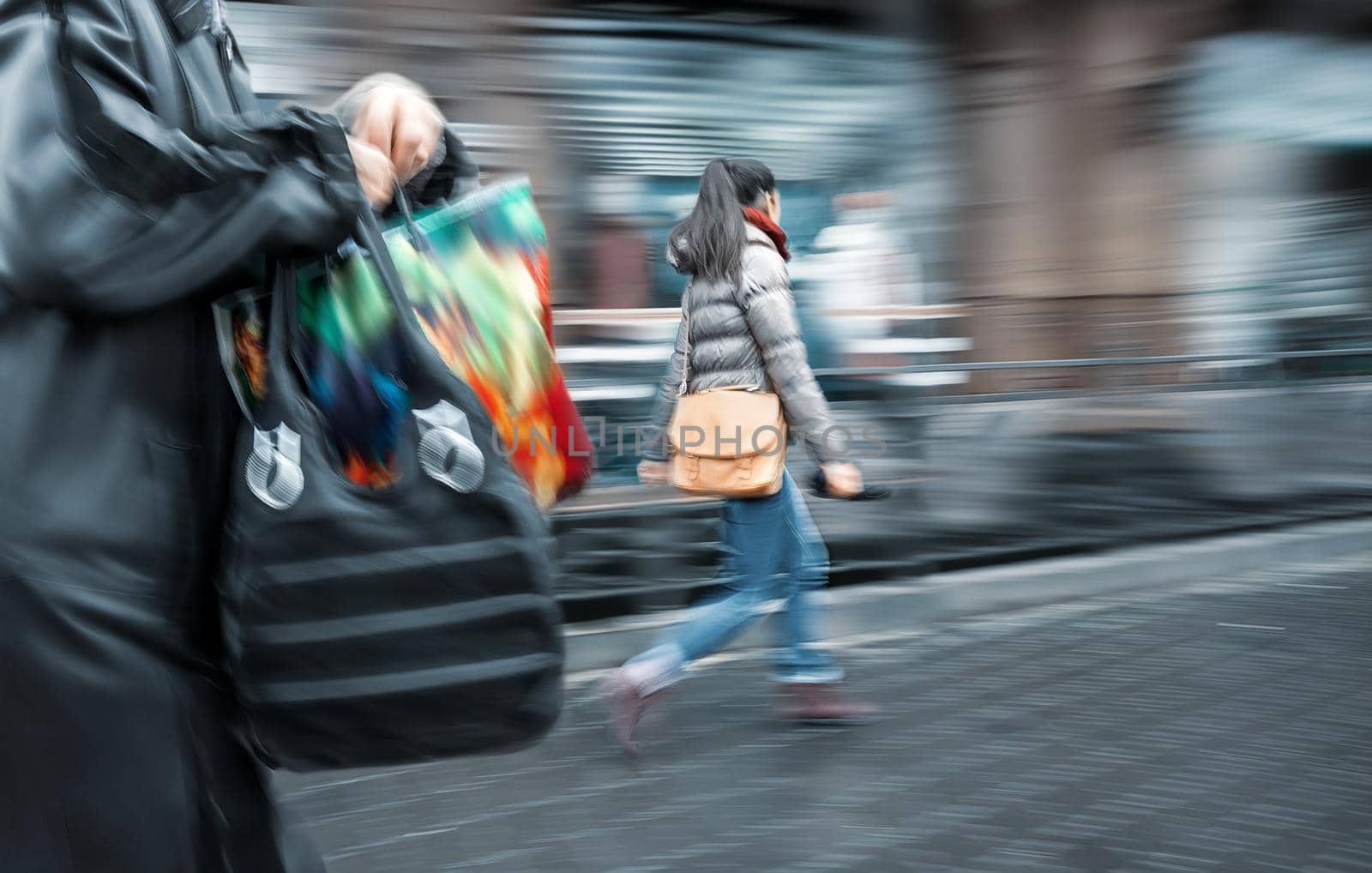 People at rush hour walking in the street.  Intentional motion blur