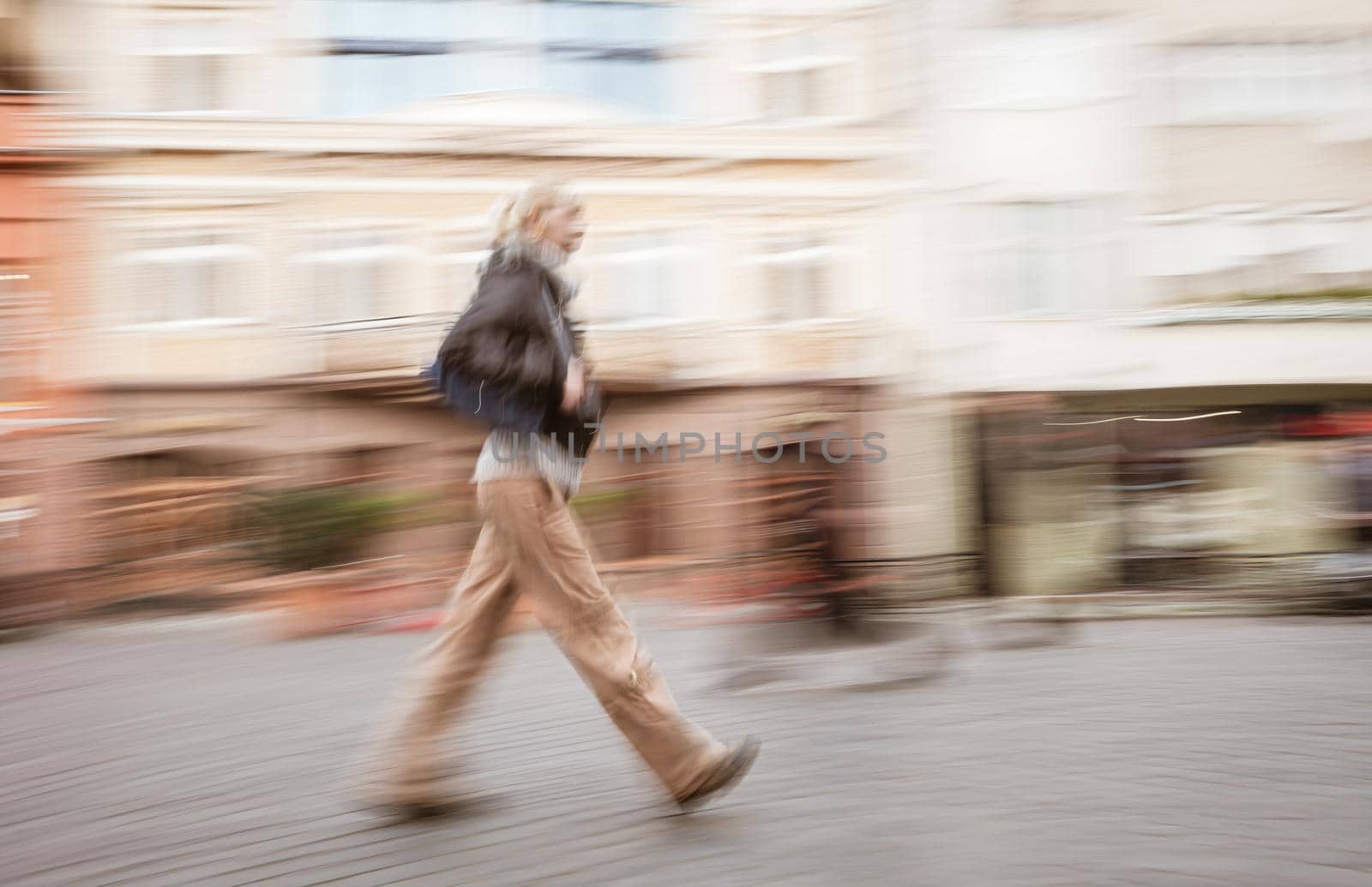 Soft focus blurred abstract image of young woman in the street. Intentional motion blur