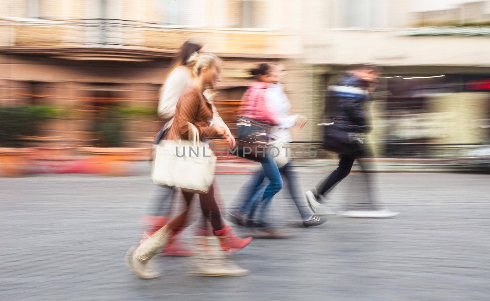 A group of young people going along the street. Intentional motion blur