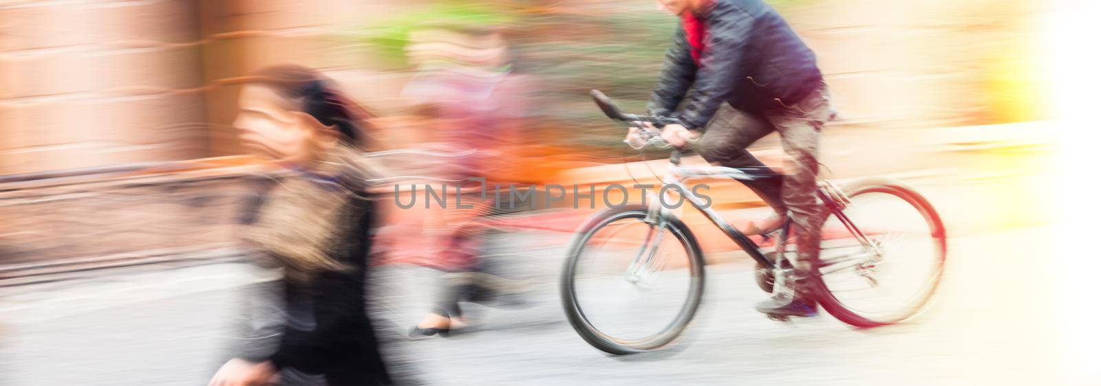 Abstract blurred image of cyclist on the city roadway. Intentional motion blur