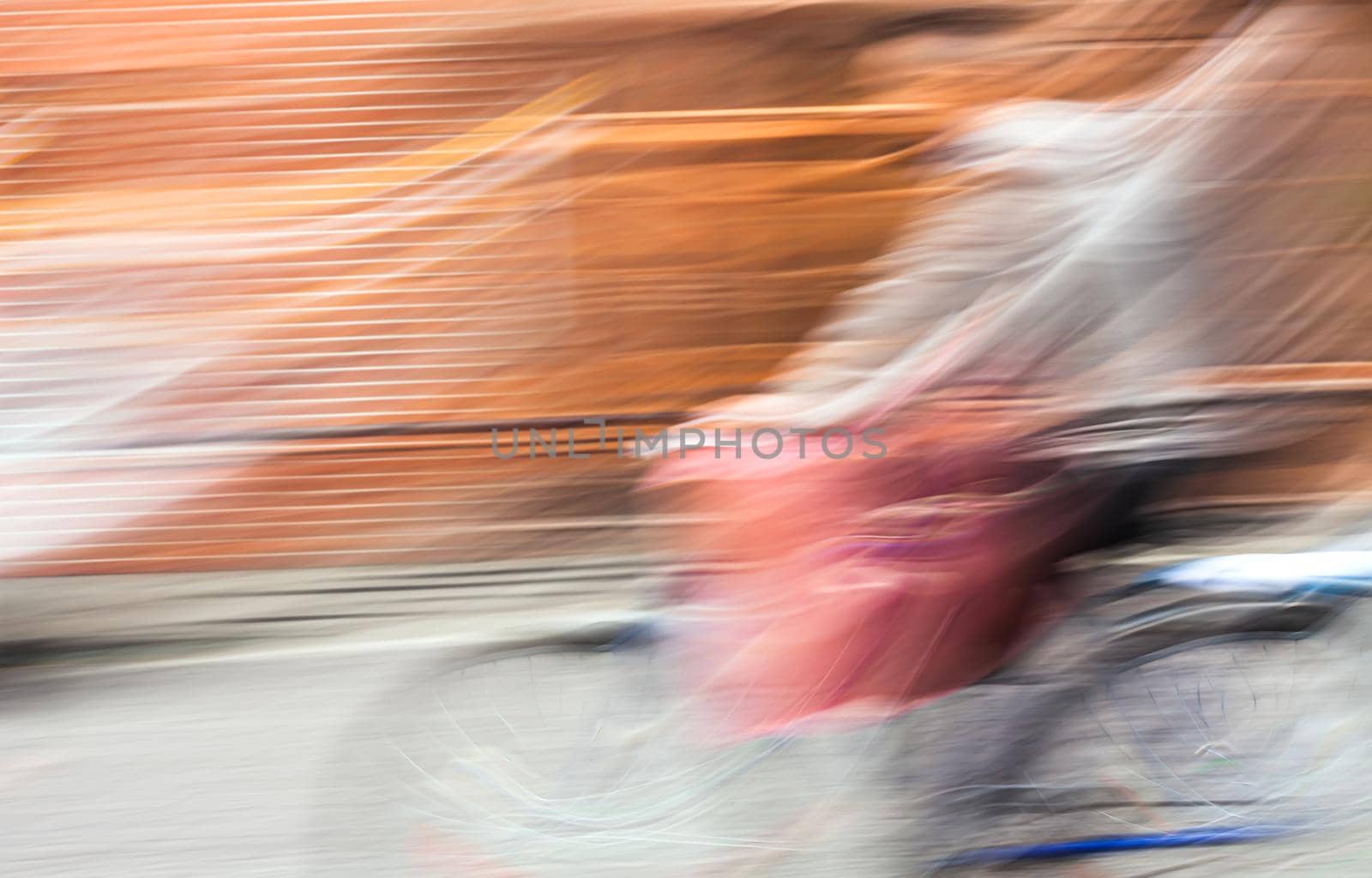 Abstract blurred image of cyclist on the city roadway. Intentional motion blur