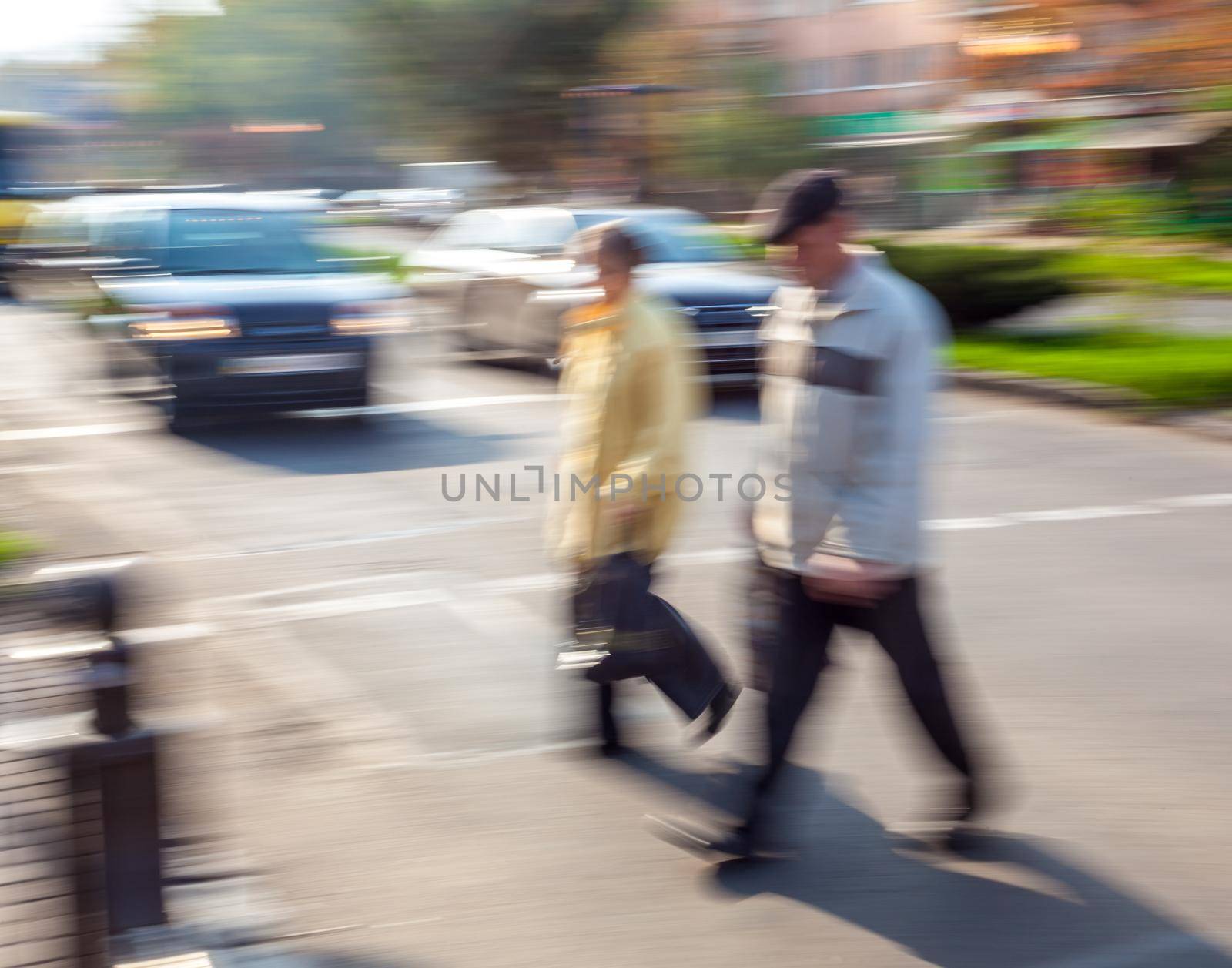 Group of people crossing the street at a crosswalk. Intentional motion blur