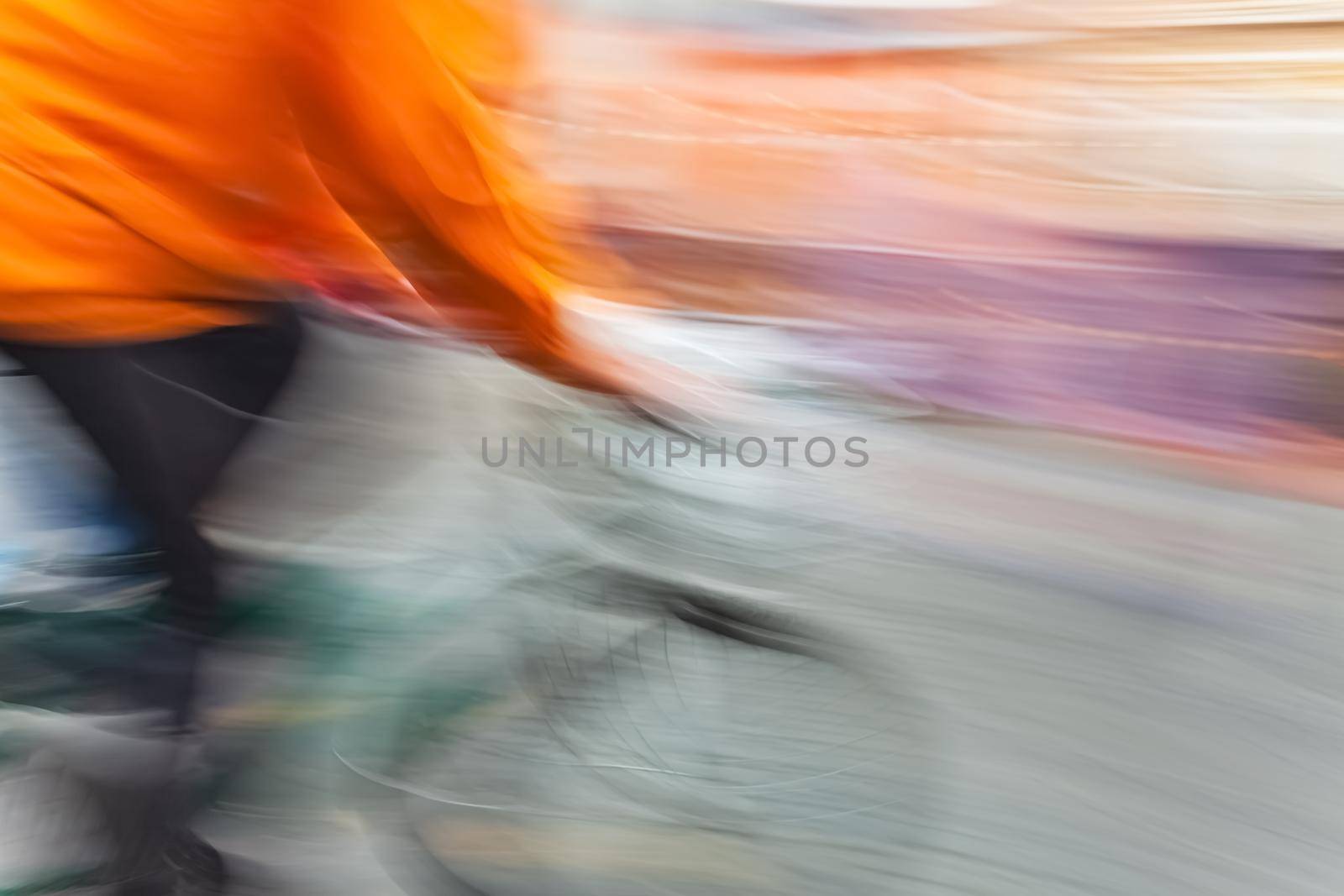 Abstract blurred image of cyclist on the city roadway. Intentional motion blur