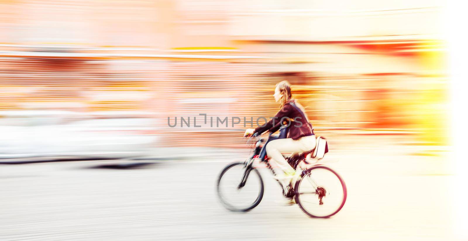Abstract blurred image of cyclist on the city roadway. Intentional motion blur