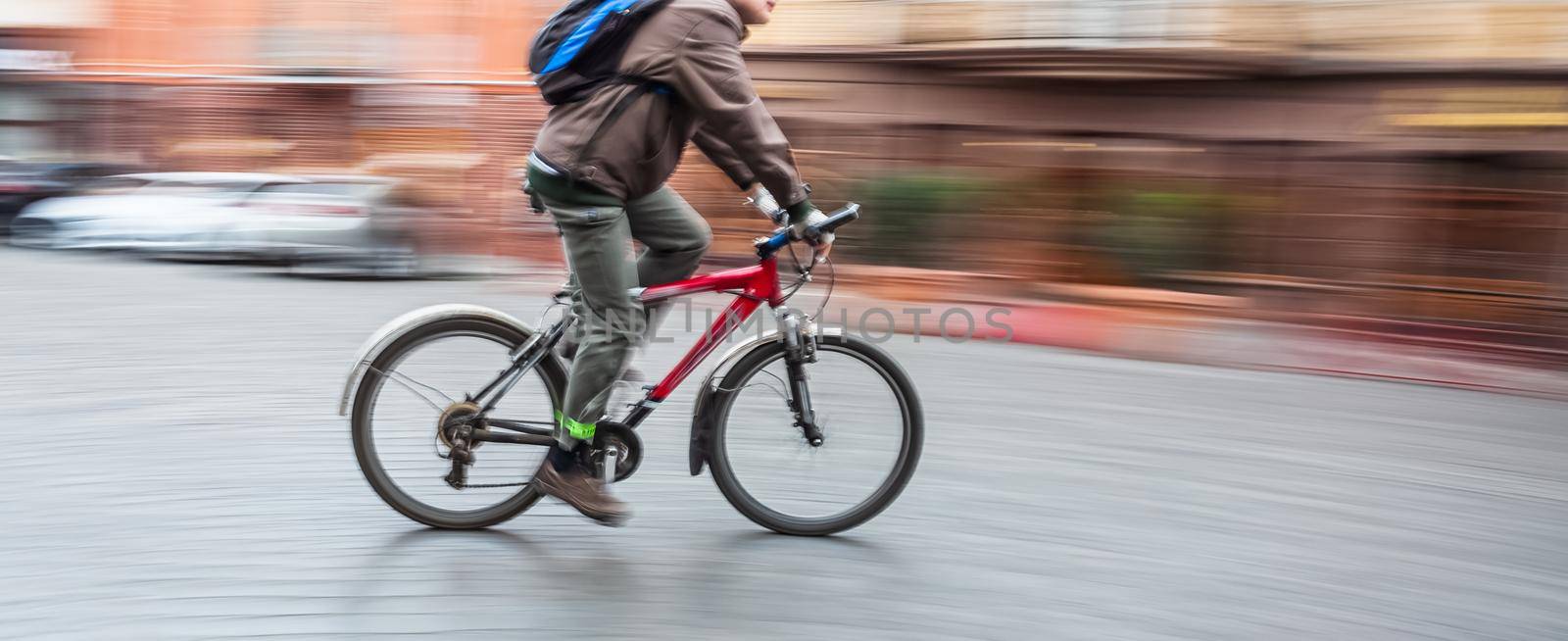 Abstract blurred image of cyclist on the city roadway. Intentional motion blur