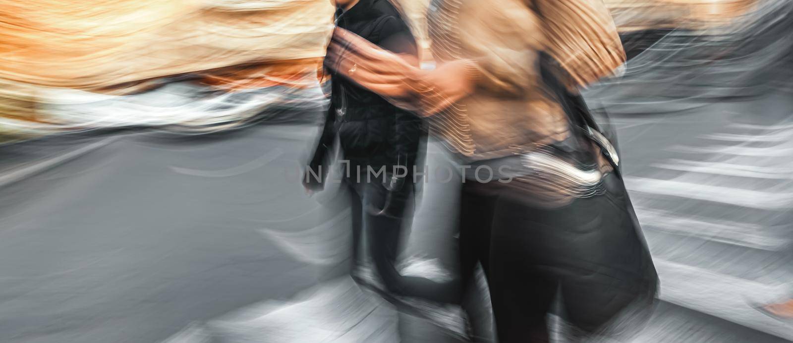 Group of people crossing the street at a crosswalk. Intentional motion blur