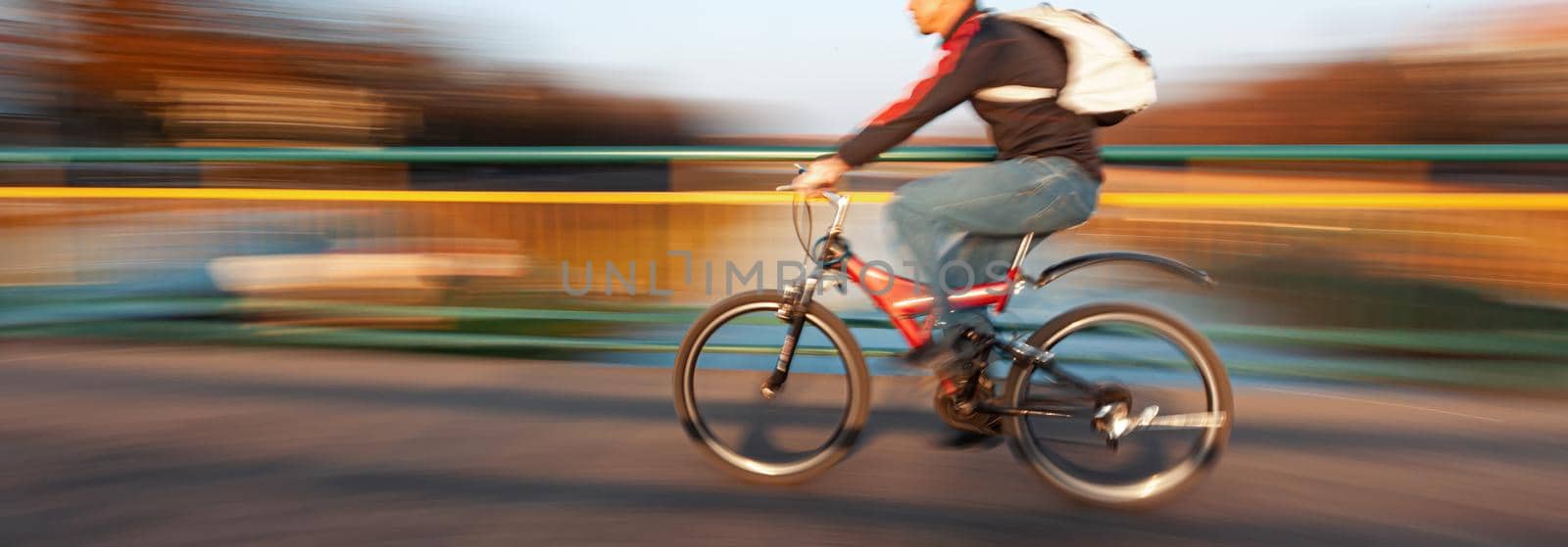 Abstract blurred image of cyclist on the city roadway. Intentional motion blur