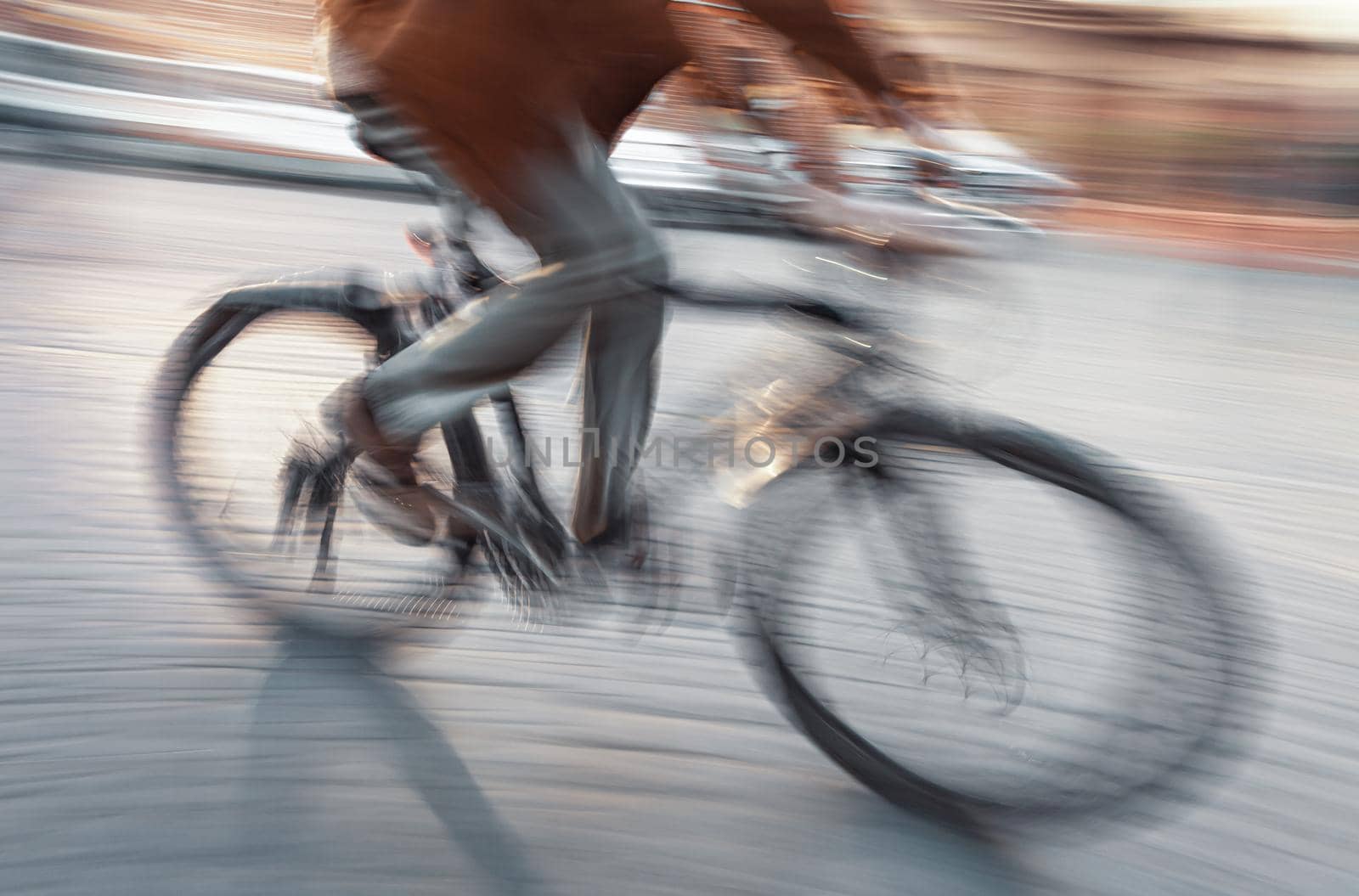 Abstract blurred image of cyclist on the city roadway. Intentional motion blur