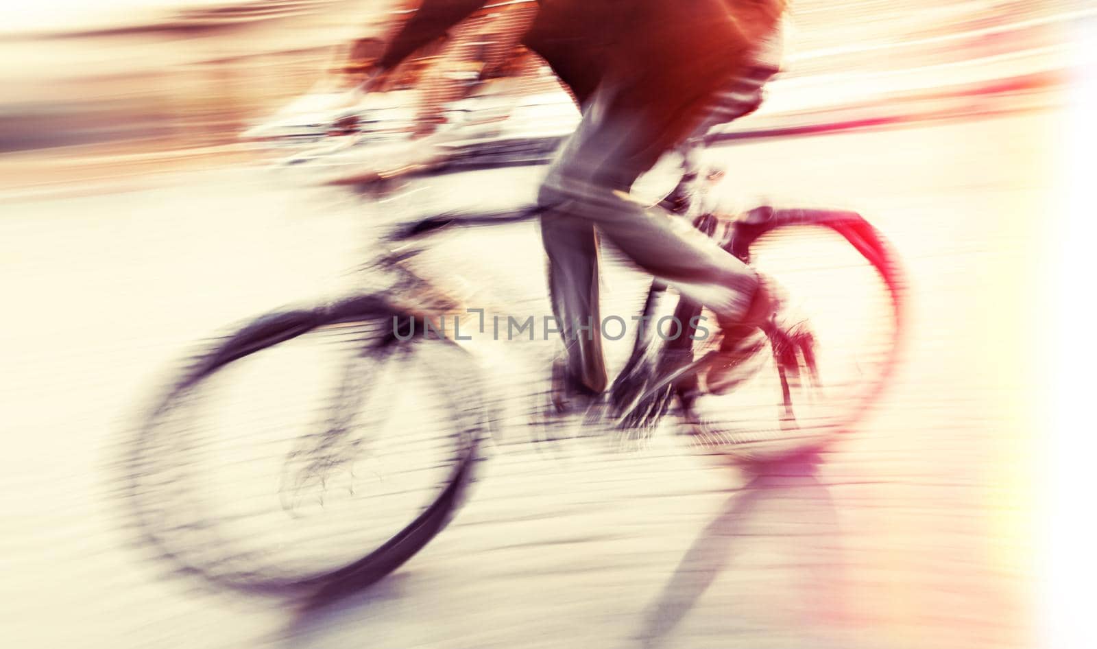 Abstract blurred image of cyclist on the city roadway. Intentional motion blur. Vintage filter with intentional color shift