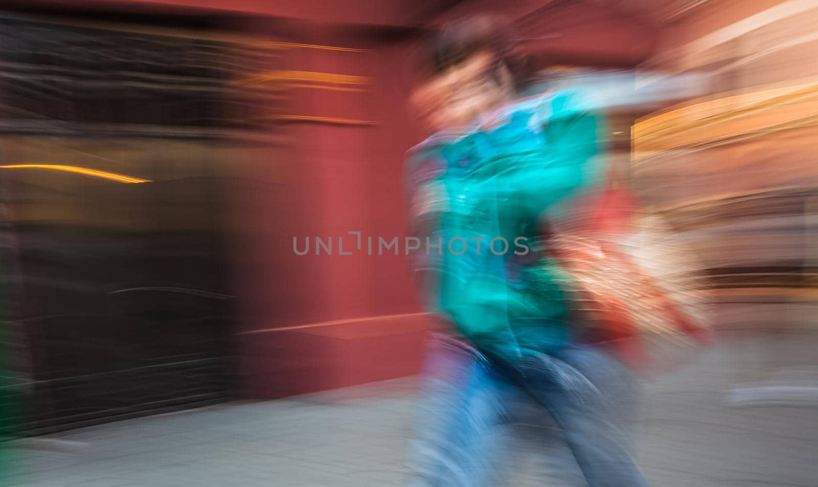 Abstract image of a young woman talking on a cell phone in a hurry. Intentional motion blur