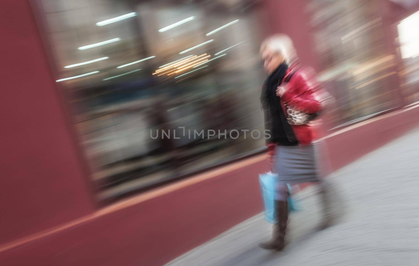 Abstract image of a woman walking down the street. Intentional motion blur
