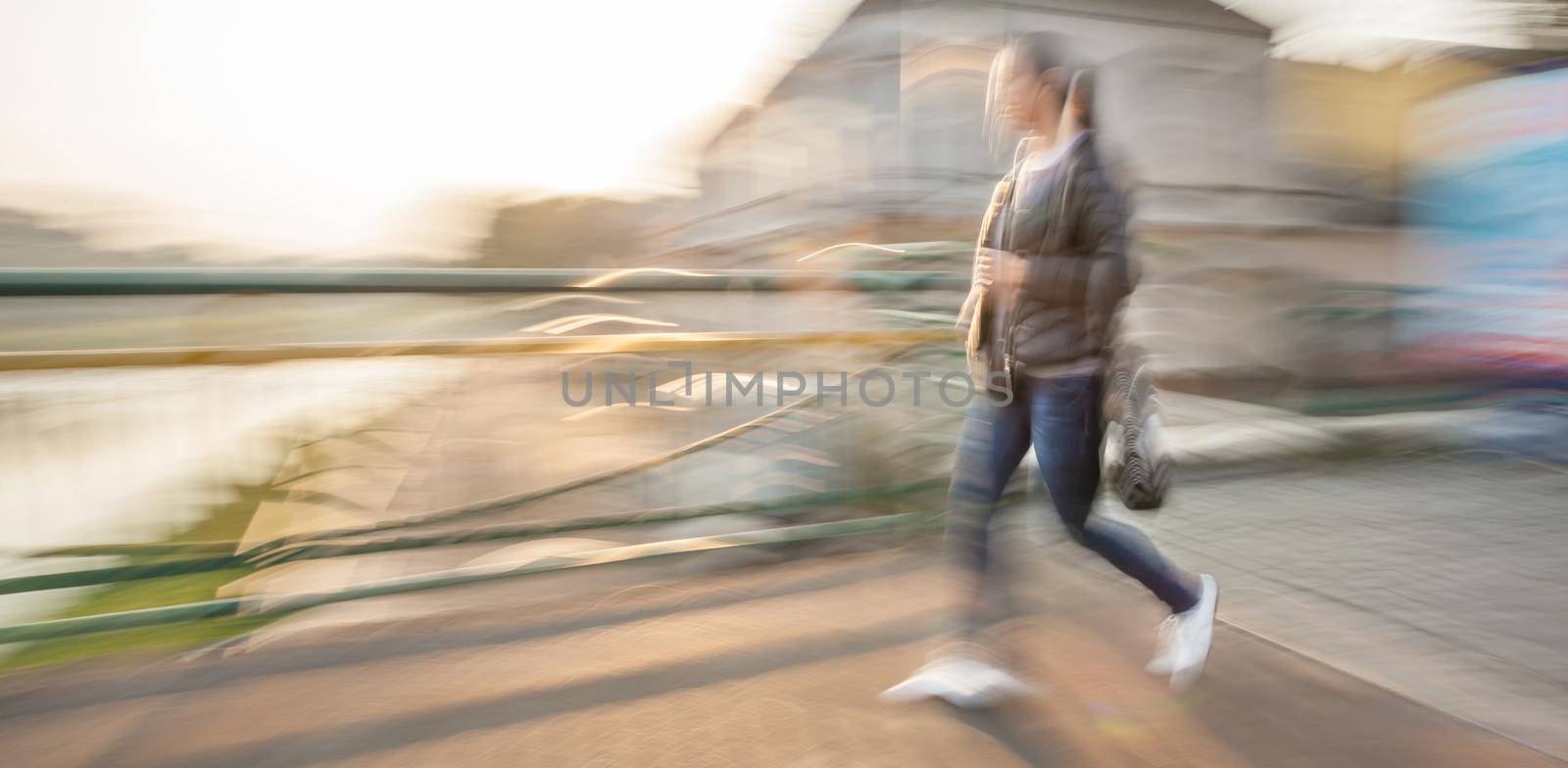 Abstract image of a woman walking down the street. Intentional motion blur