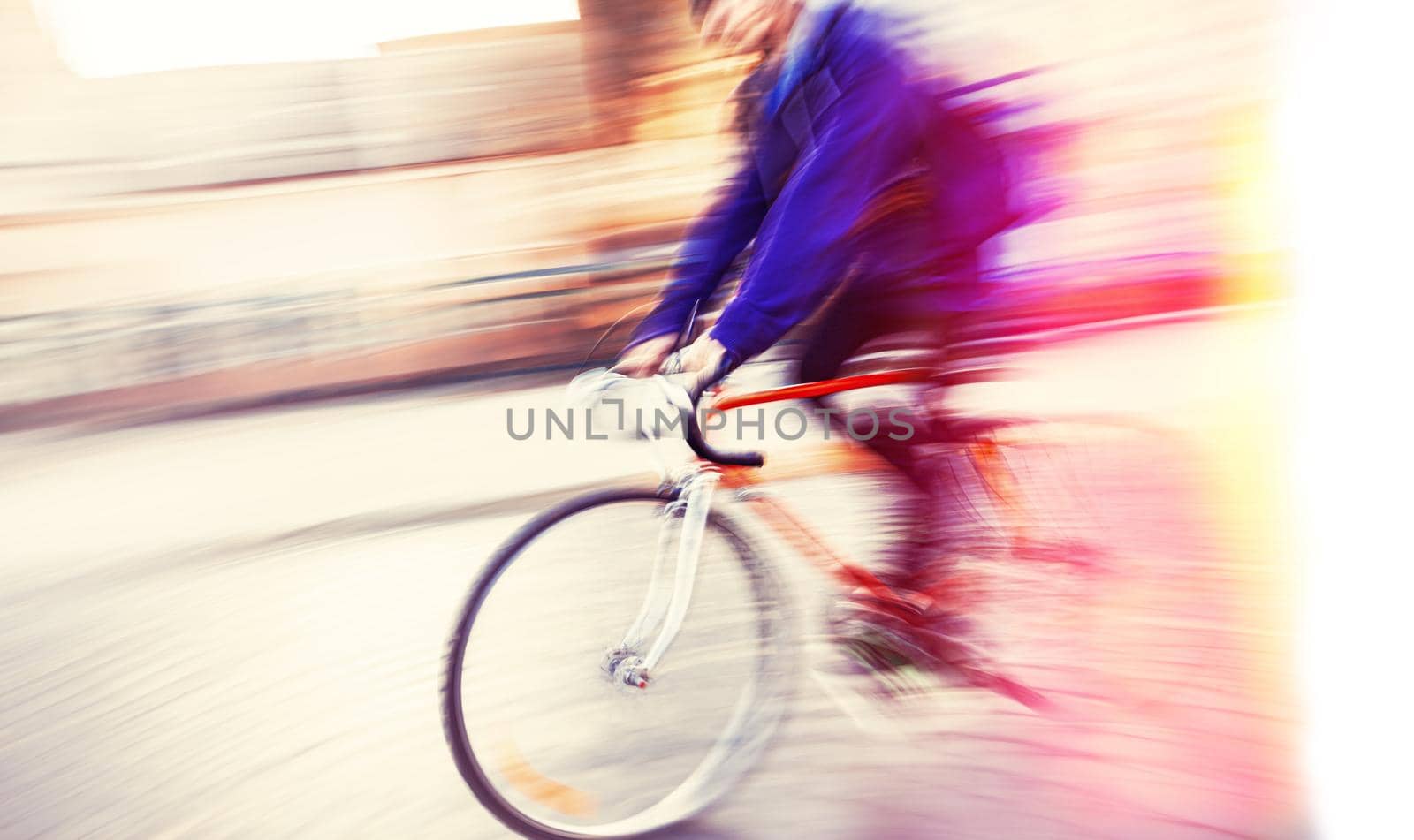 Abstract blurred image of cyclist on the city roadway. Intentional motion blur. Vintage filter with intentional color shift